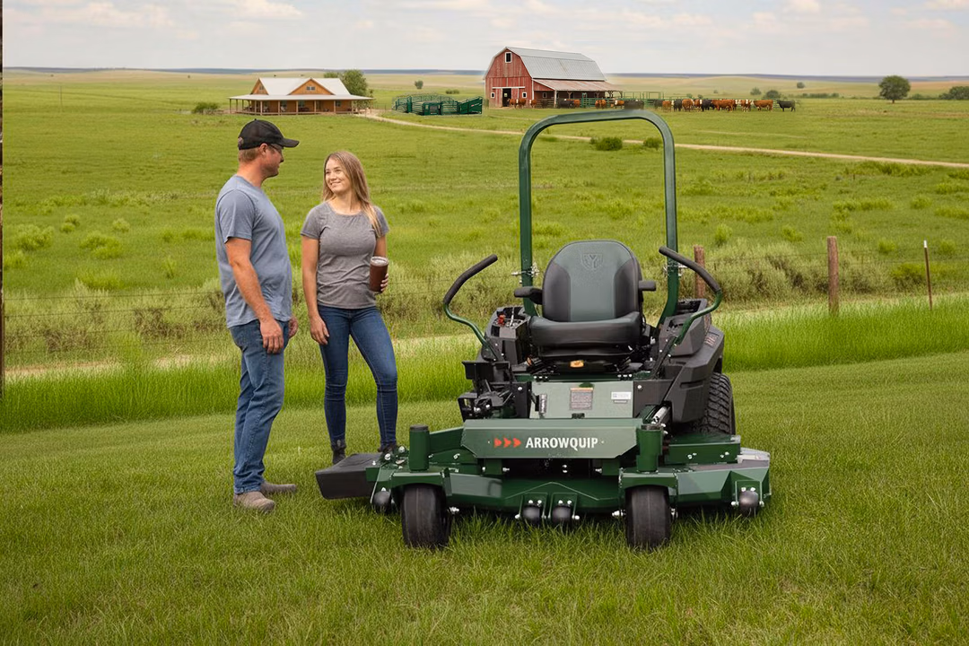 Young couple on their ranch with their mower