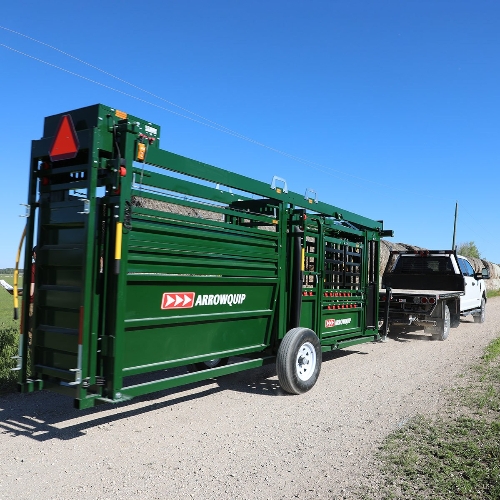 Q-Catch 87 Series Cattle Chute & Alley being towed down a dirt road