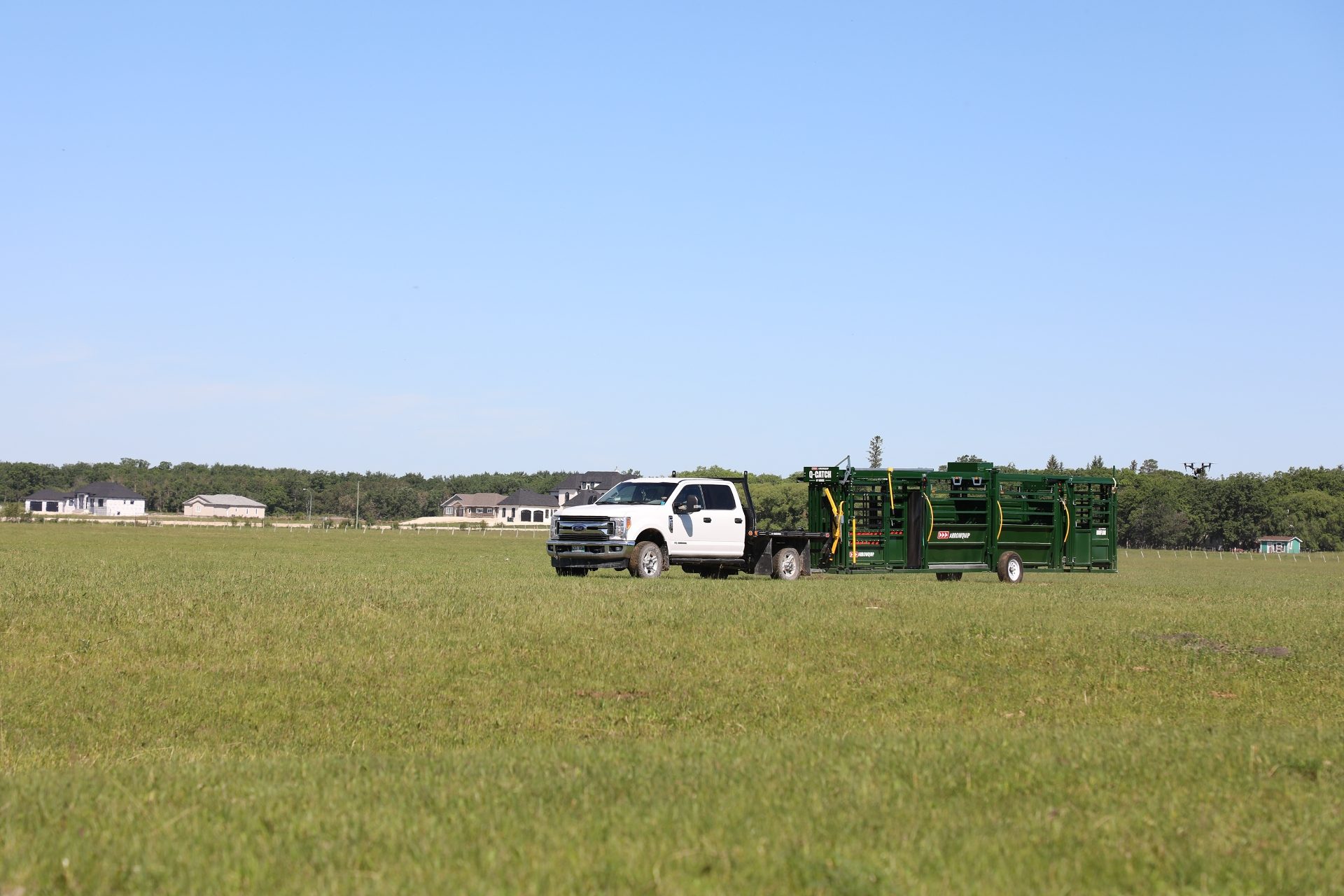 Q-Catch 87 Series Portable Cattle Handling System with 18' Alley being towed across grass field