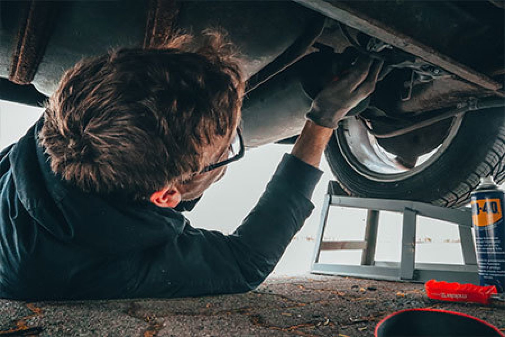 Man under vehicle fixing engine